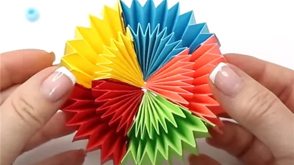 В руках держат круг, сложенный из разноцветных листов бумаги «гармошкой»